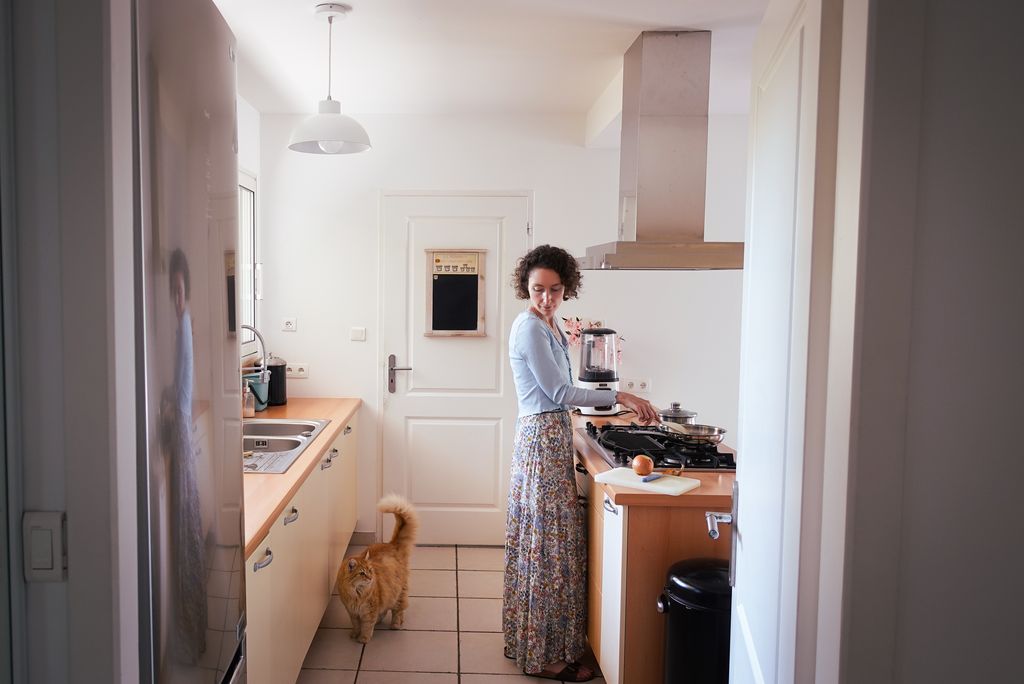 Jeune femme en jupe longue à fleurs dans une cuisine